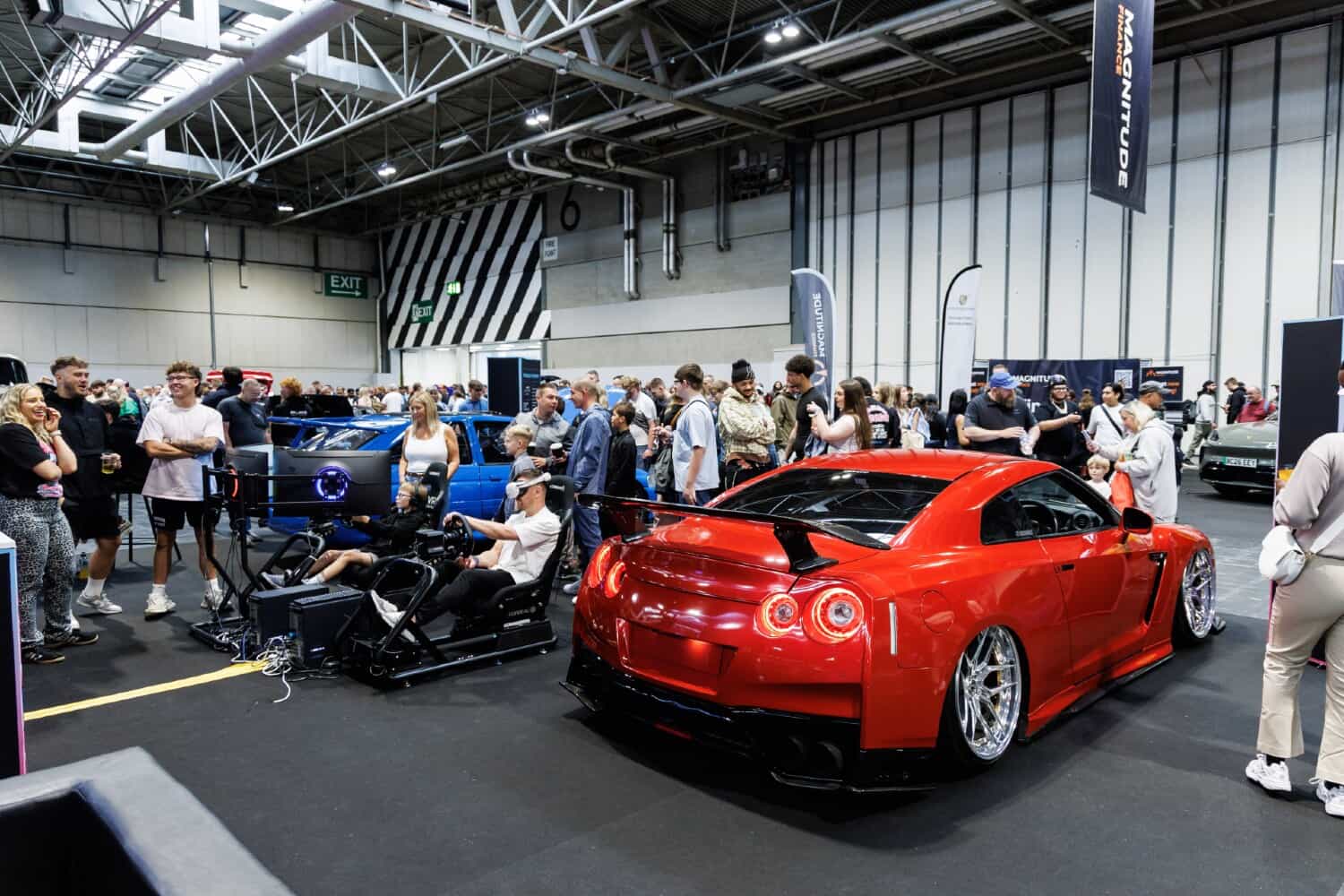 Crowds at a UK automotive show beside a modified Nissan GT-R