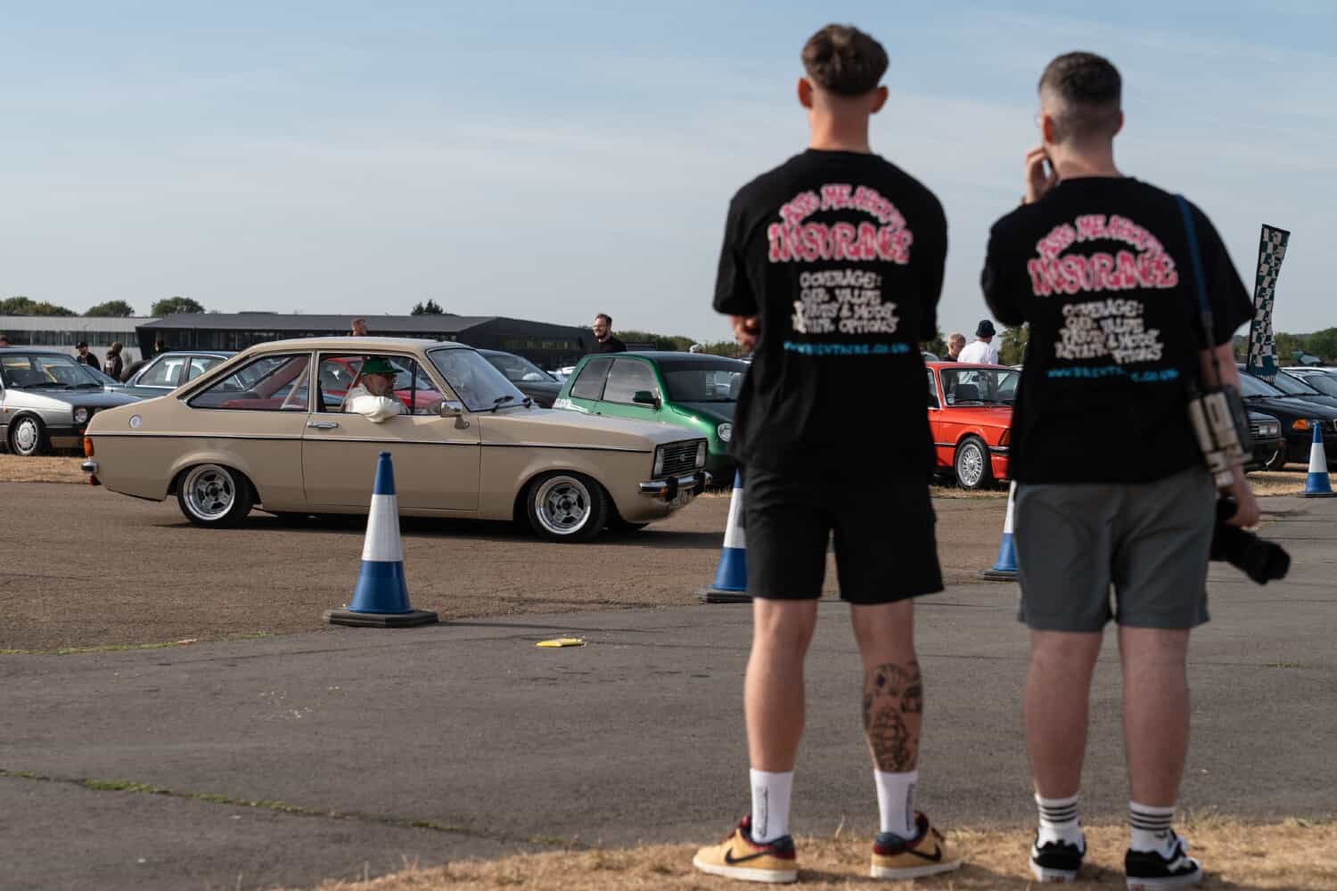 Two members of the Brentacre team at a classic car show watching a Ford Escort arrive
